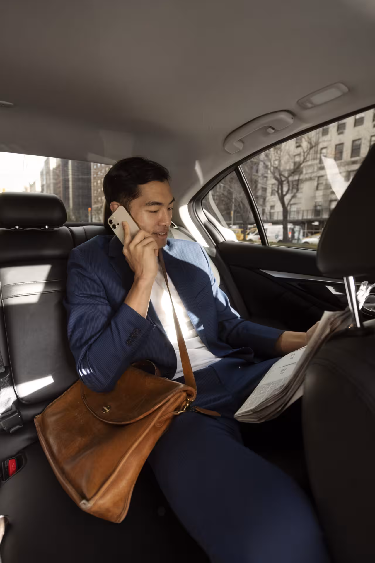 Professionista in giacca e cravatta che lavora durante un transfer privato in auto.